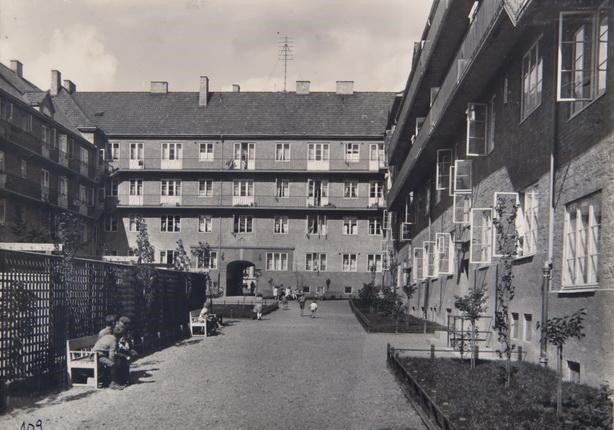 Sort-hvitt-foto av gammel bygård sett fra indre gårdsplass