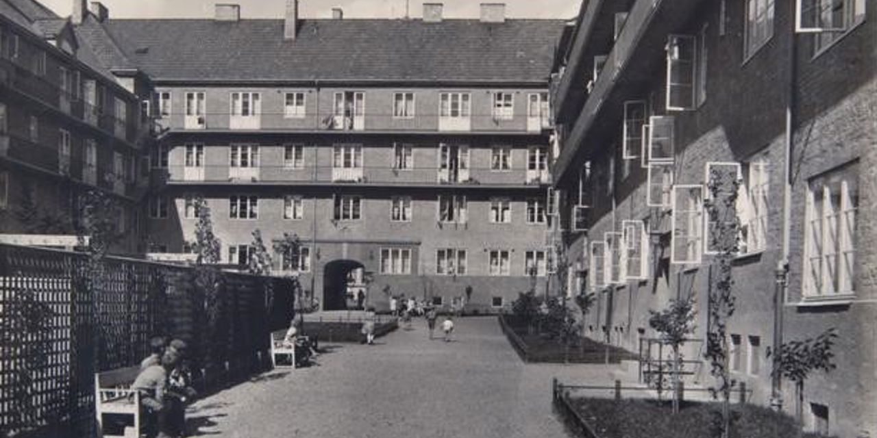Sort-hvitt-foto av gammel bygård sett fra indre gårdsplass