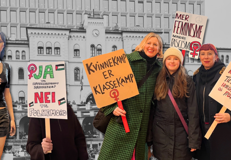 Kvinner med plakater med slagord på foran sort-hvitt-foto av Youngstorget