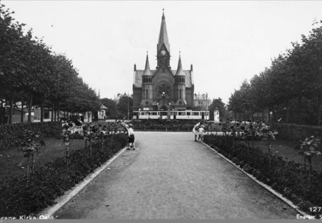 sorthvitt av symmetrisk park med trær på begge sider og en stor kirke i midten