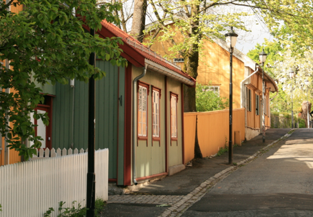 Grønne og gule trehus langs en liten gate