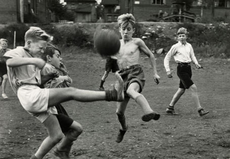 Gutter som sparker fotball