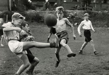 Gutter som sparker fotball