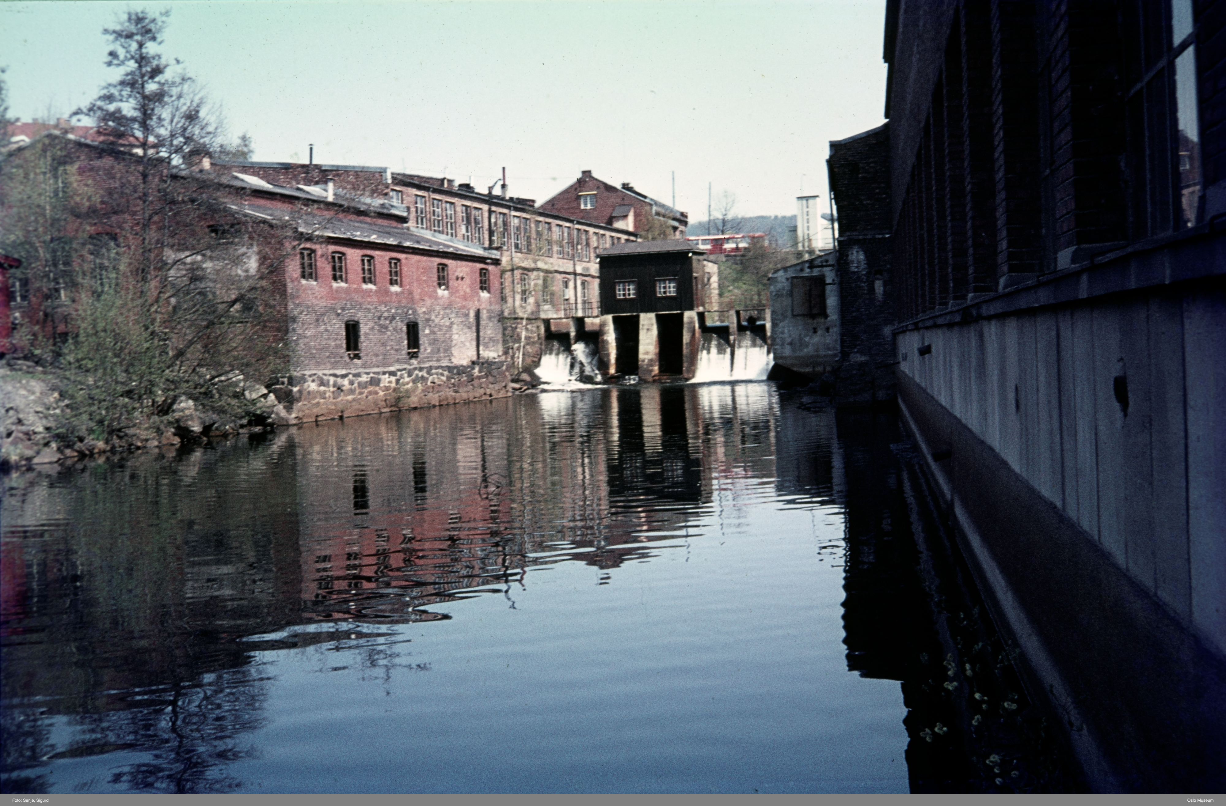 Elv med demning og murbygg rundt