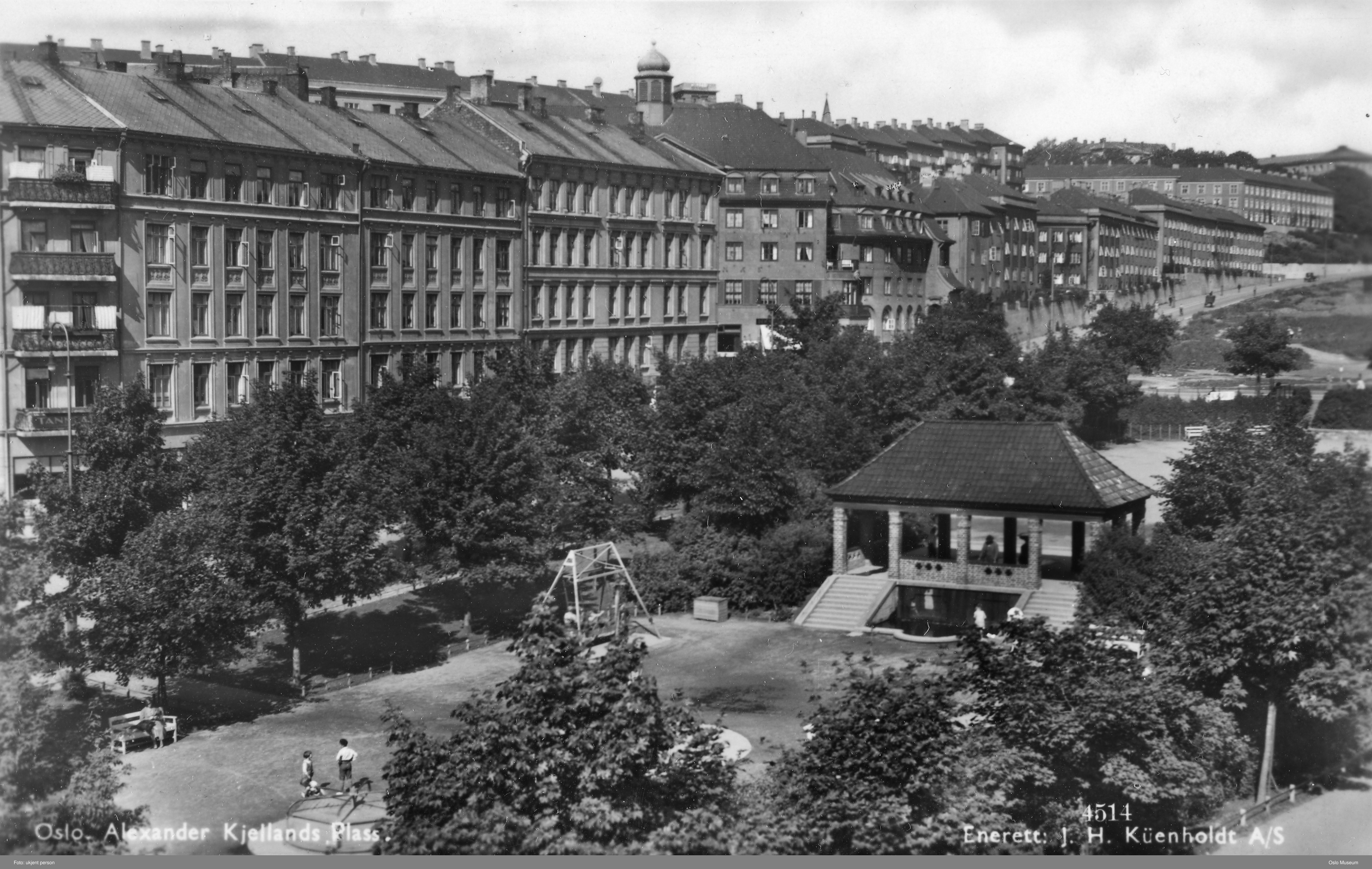 Sorthvitt-bilde oversikt over en park med paviljong og trær med boligblokker langs parken
