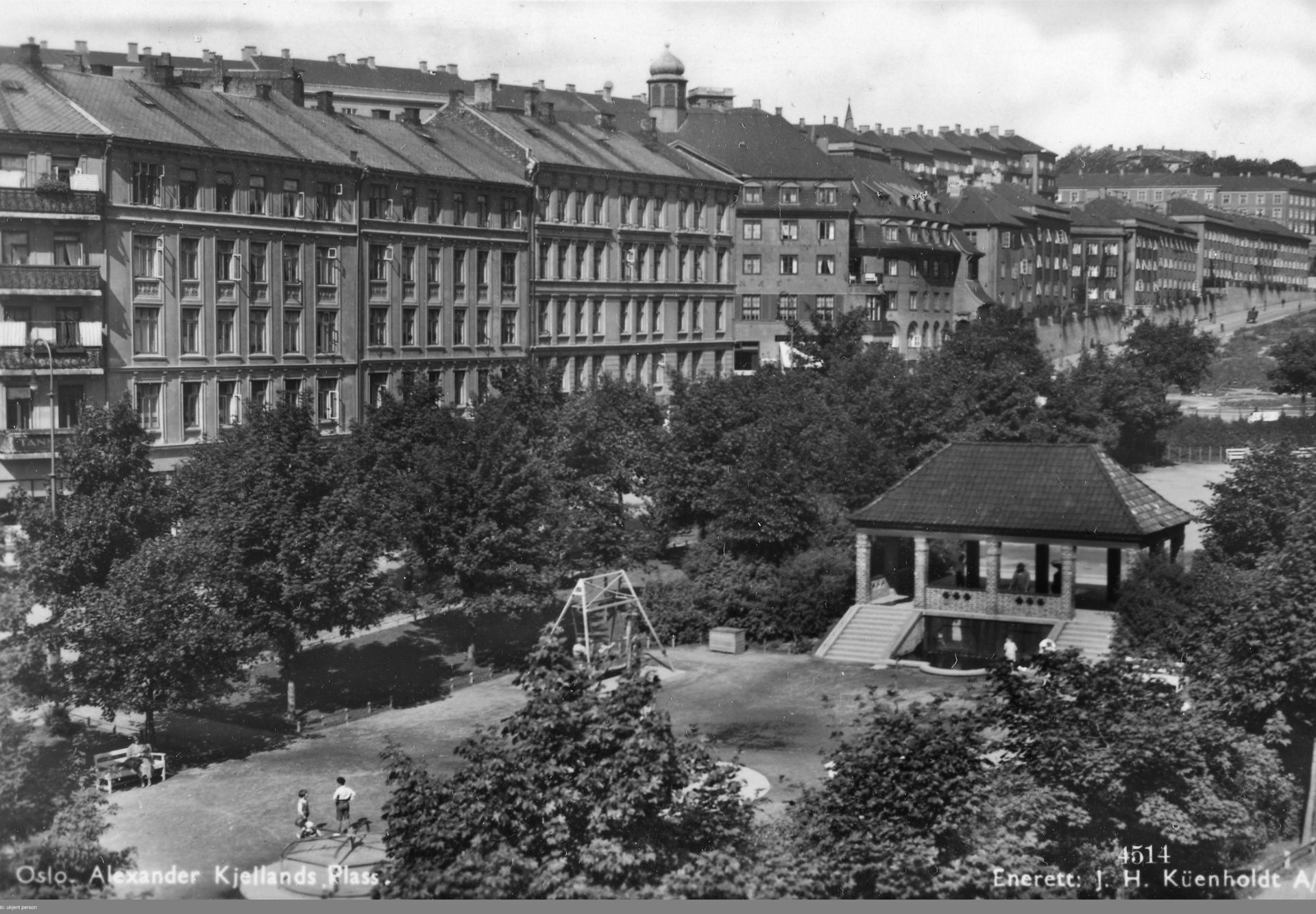Sorthvitt-bilde oversikt over en park med paviljong og trær med boligblokker langs parken