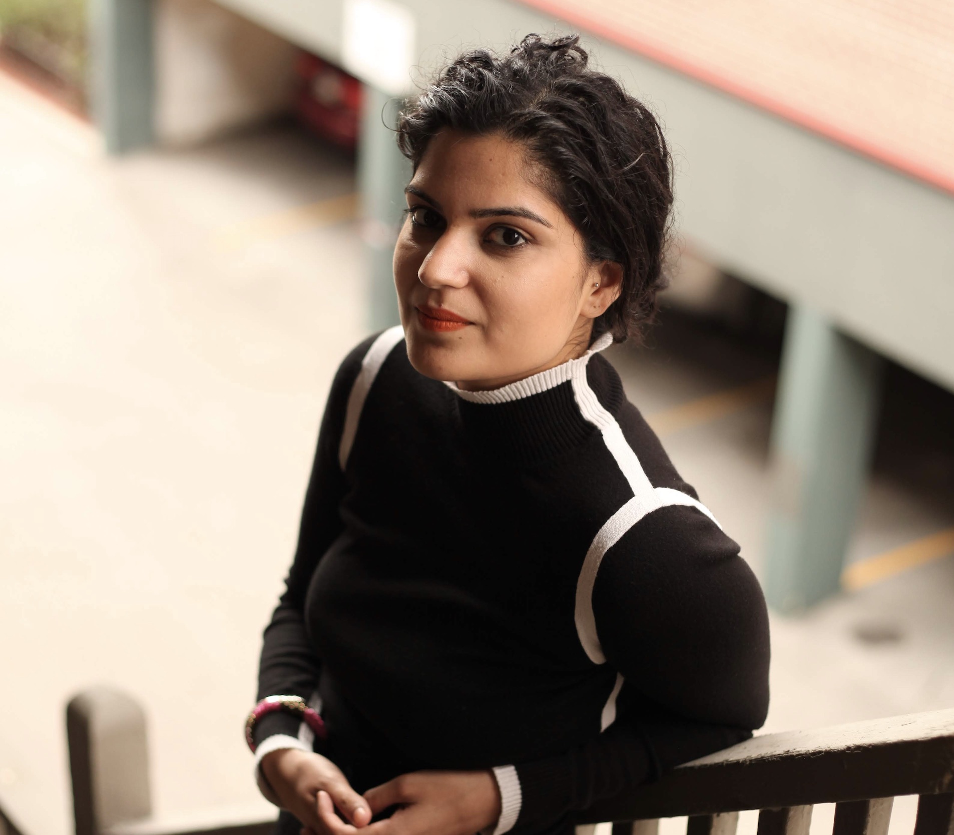 Kvinne i sort genser ser opp mot kamera