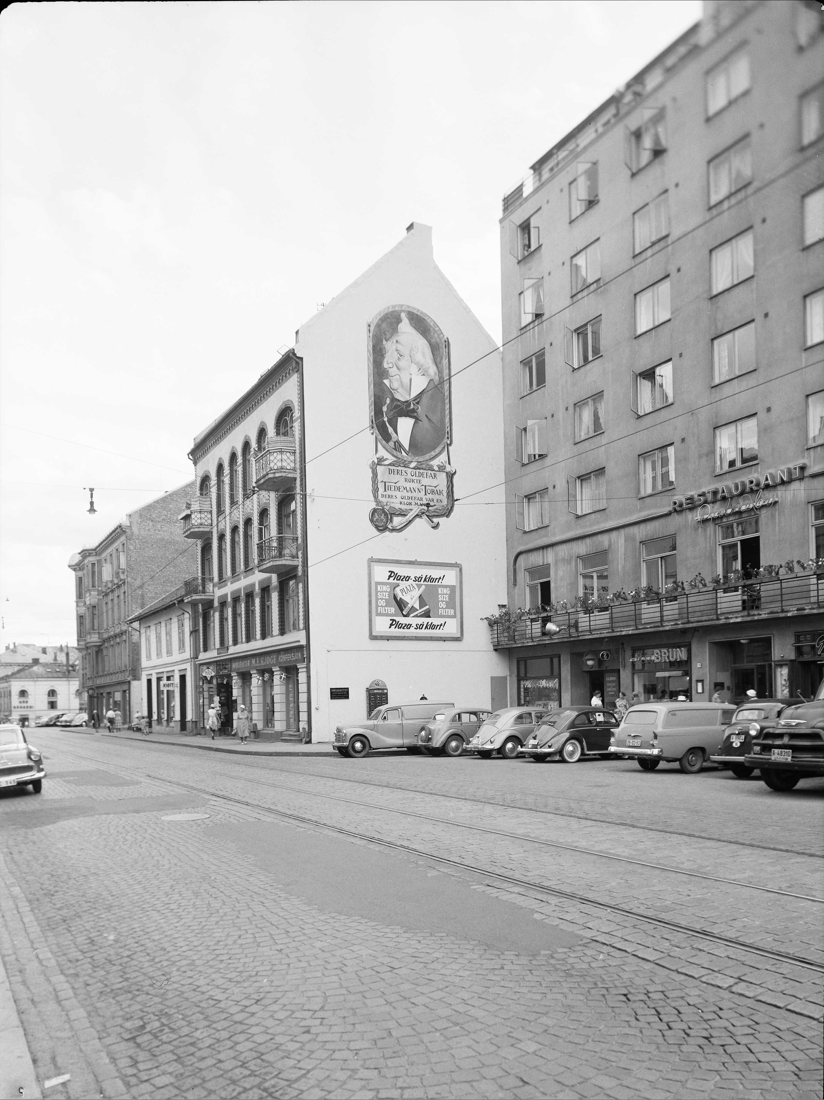 Bogstadveien with business premises, cars, people and gable advertising for Tiedemann's tobacco