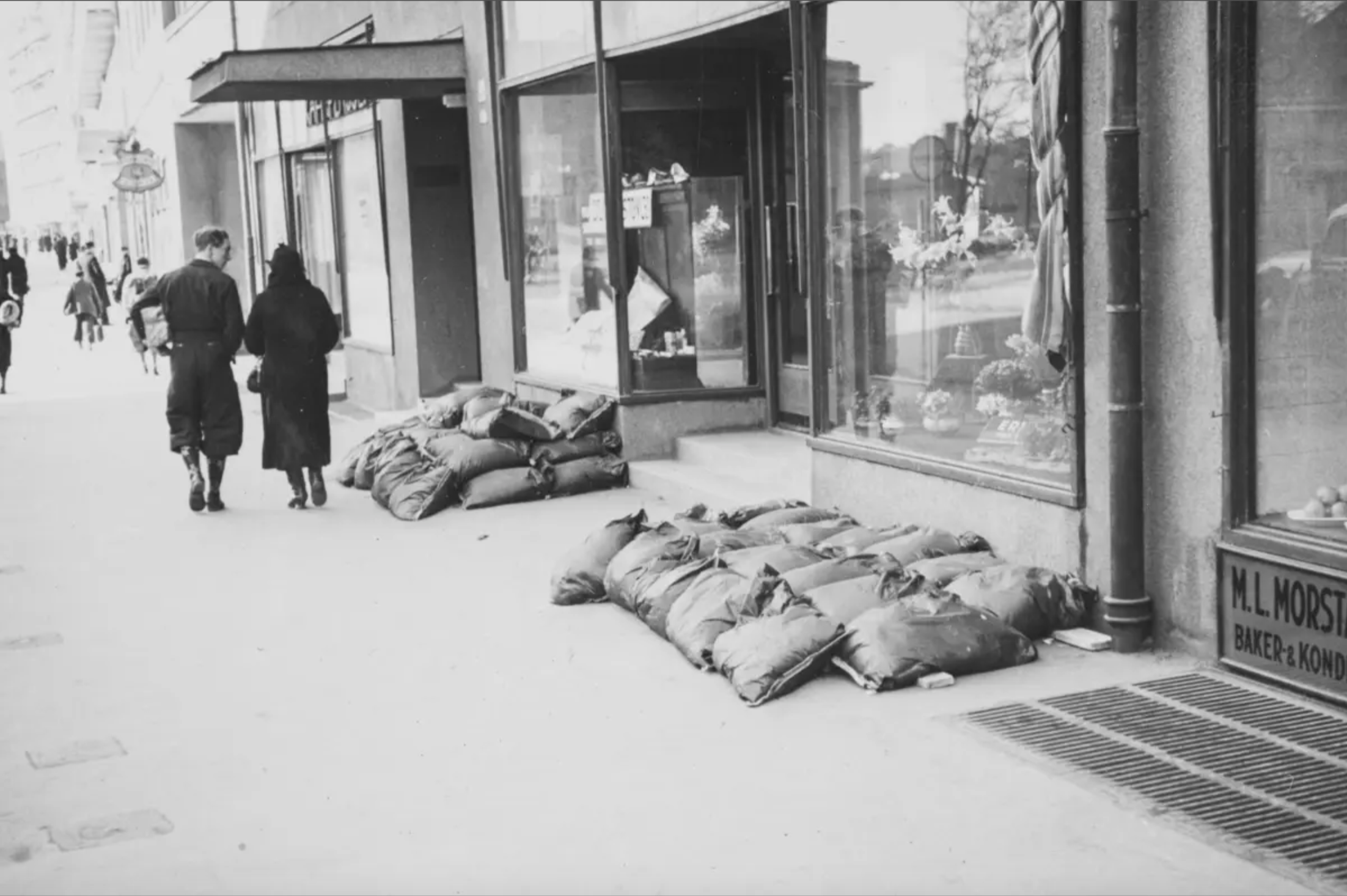 Sandsekker p&aring; gate p&aring; hver side av et butikklokale