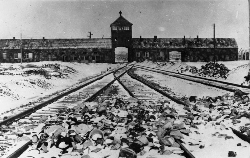 Inngangen til Auschwitz med togskinner og bygning med port