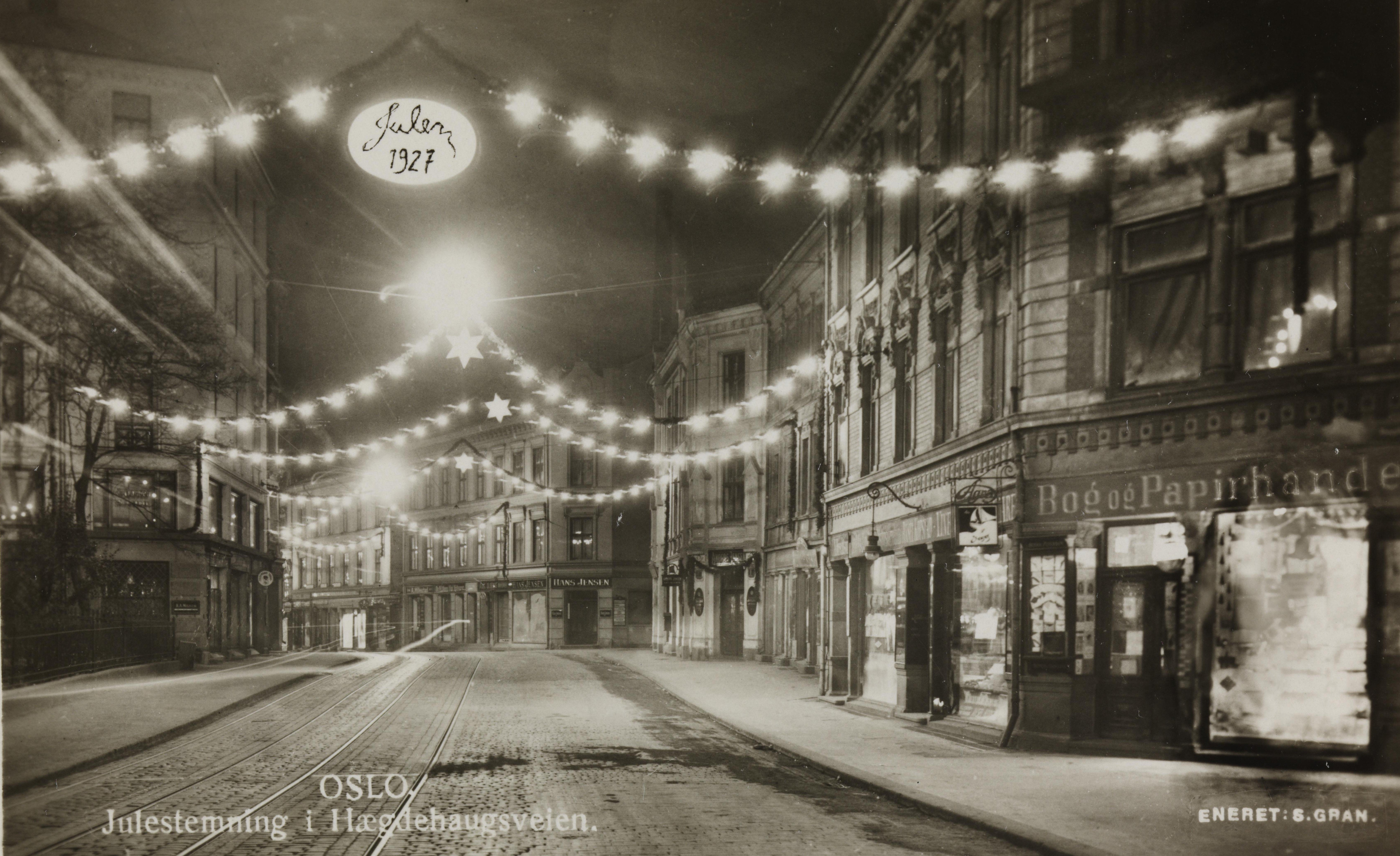sort-hvitt av julebelysning i gate med skiltet julen 1927