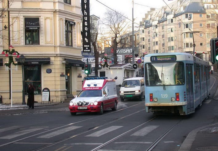 Gate med trikkeskinner, trikk og biler