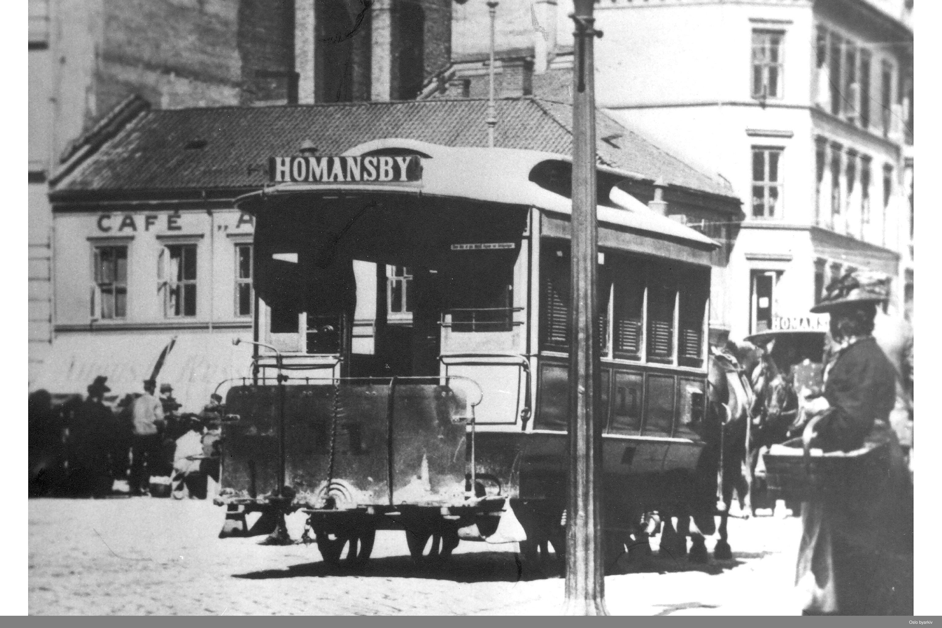 sort-hvitt av gammel hestesporvogn med skiltet Homansby