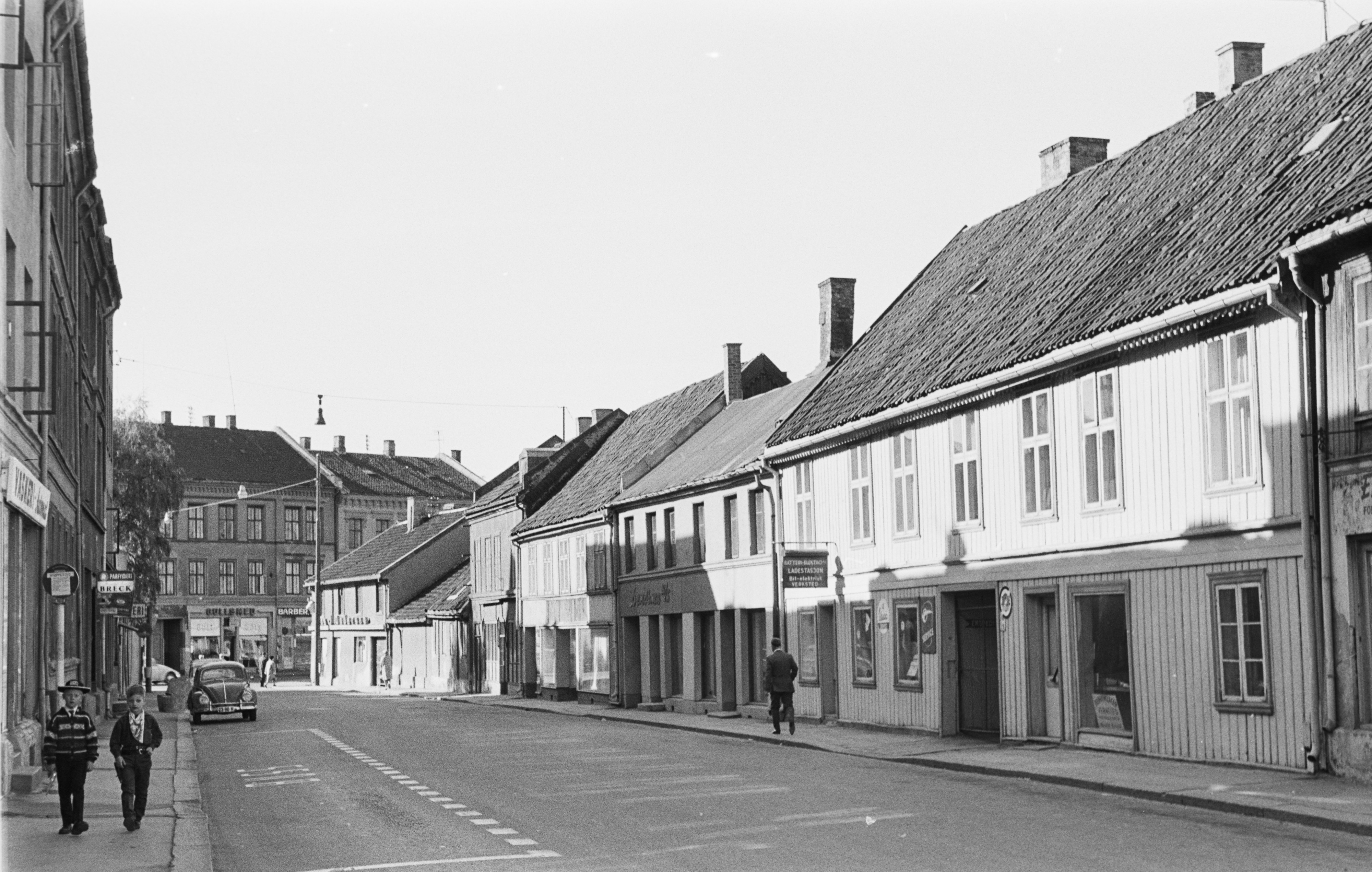 to-etasjers trehus langs en vei. sort-hvitt