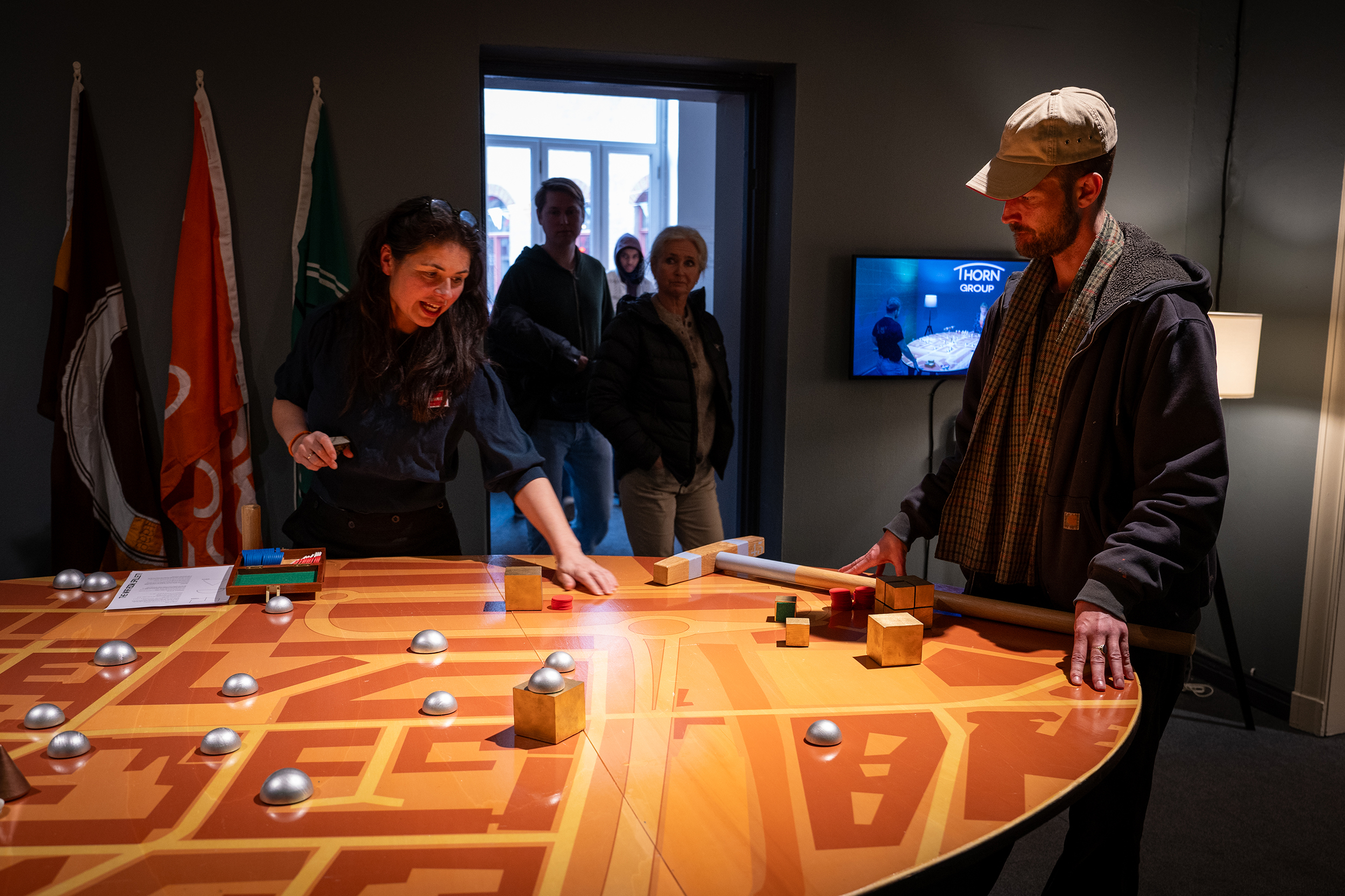 To personer spiller et spill over et stort bord med opptegnede gater.