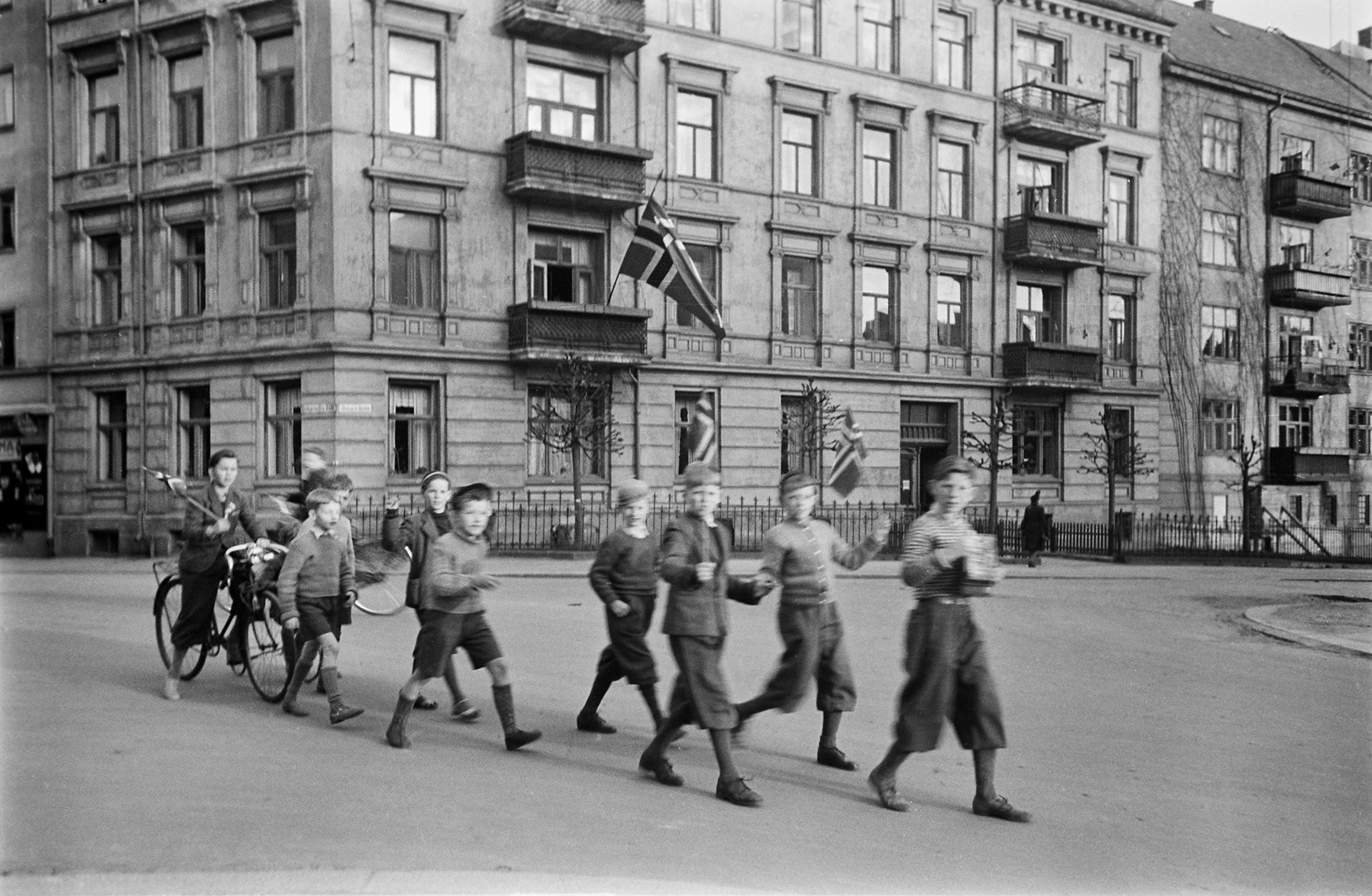 Unge gutter går i gaten med norske flagg